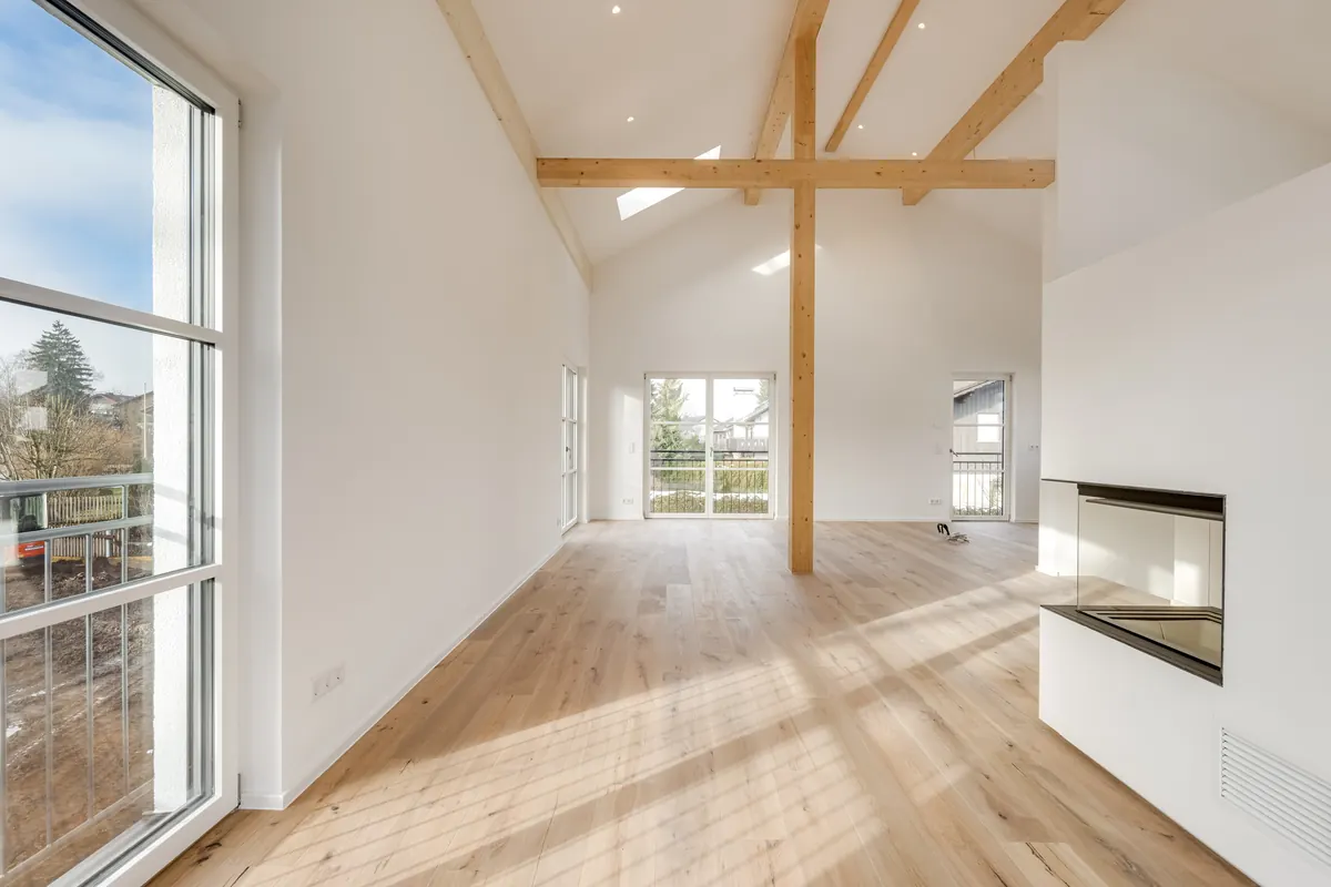 Dachraum mit Holzbalken, Kamin und hohen Fenstern
