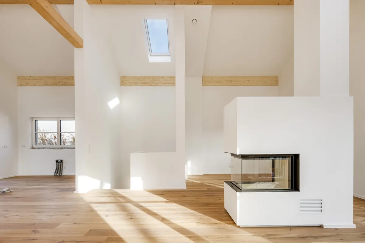 Offener Dachraum mit Holzbalken und Kamin
