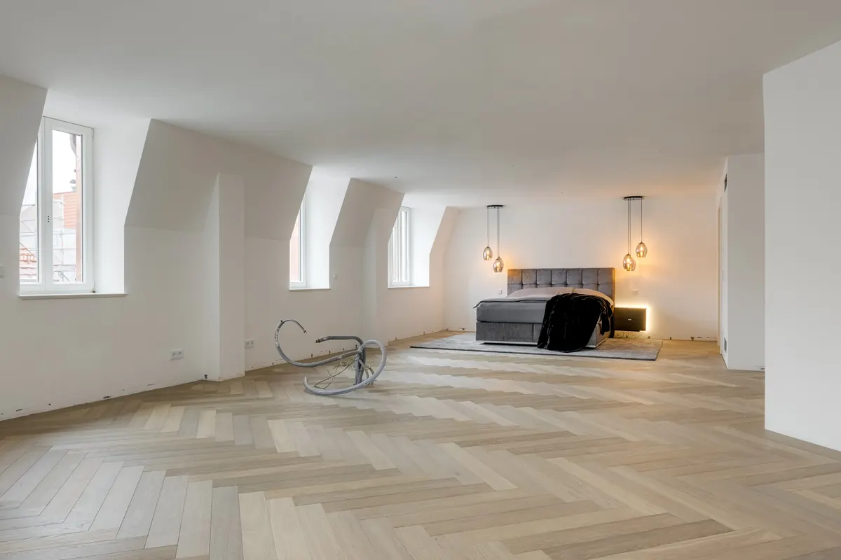Weitläufiges Schlafzimmer unter dem Dach mit Fischgrätparkett