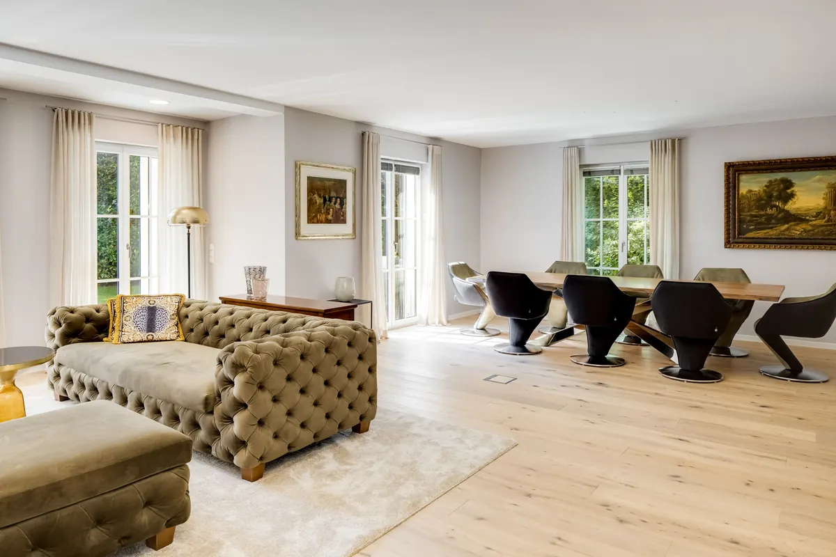Offener Wohn- und Essbereich mit Chesterfield-Sofa und Designstühlen