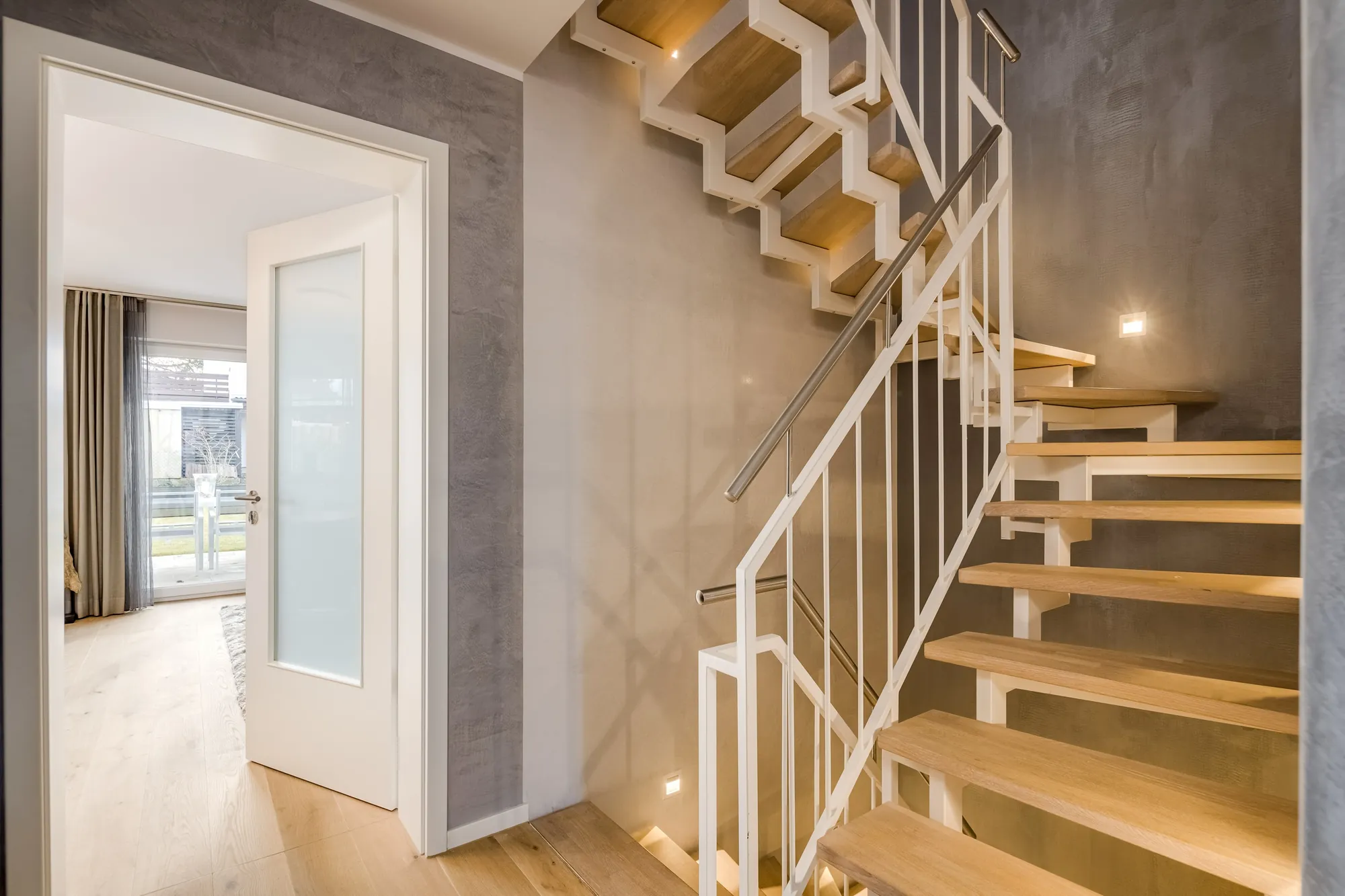 Offene Holztreppe mit weißem Geländer