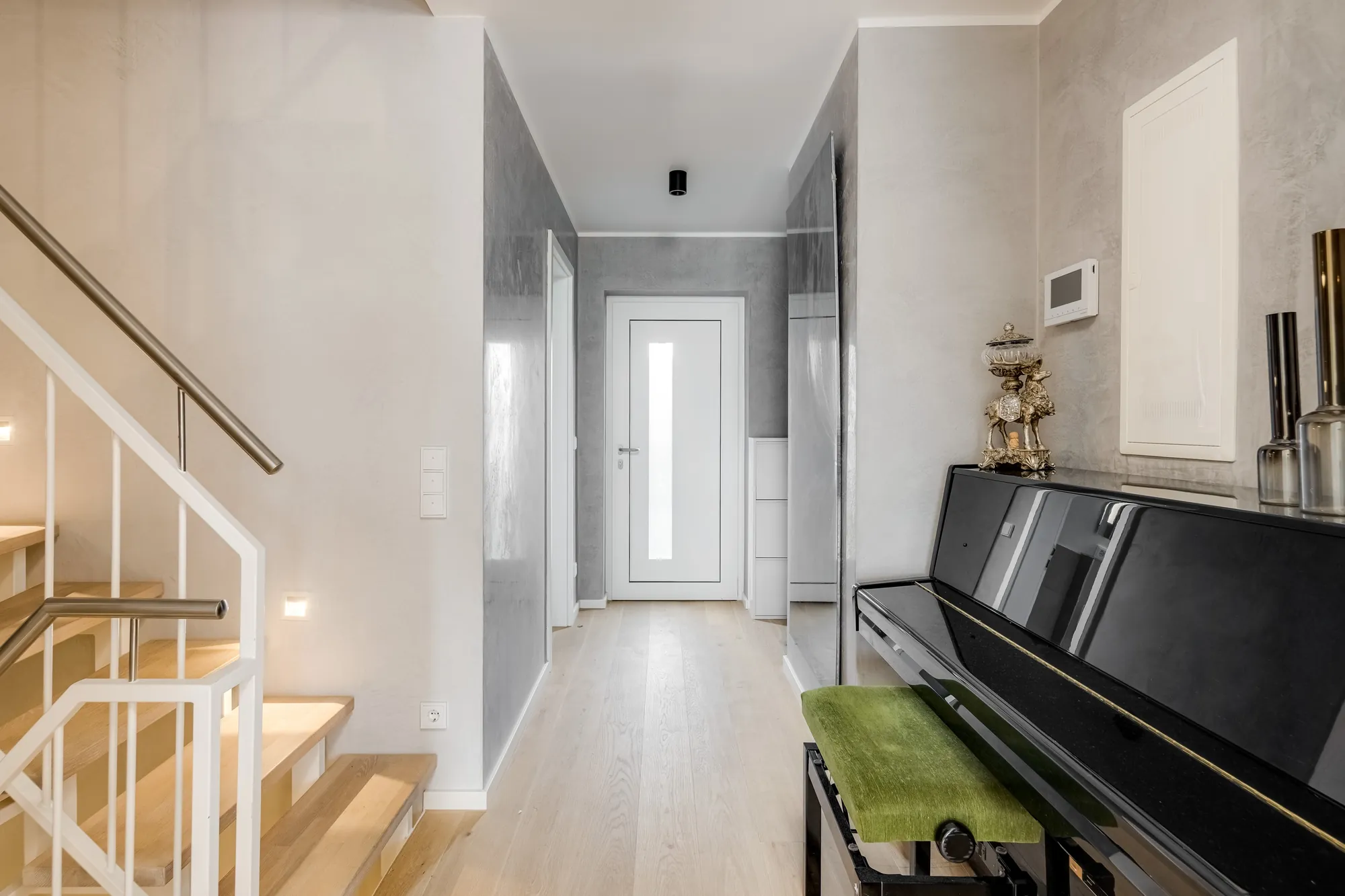 Flur mit Treppe, Klavier und Blick zur Haustür