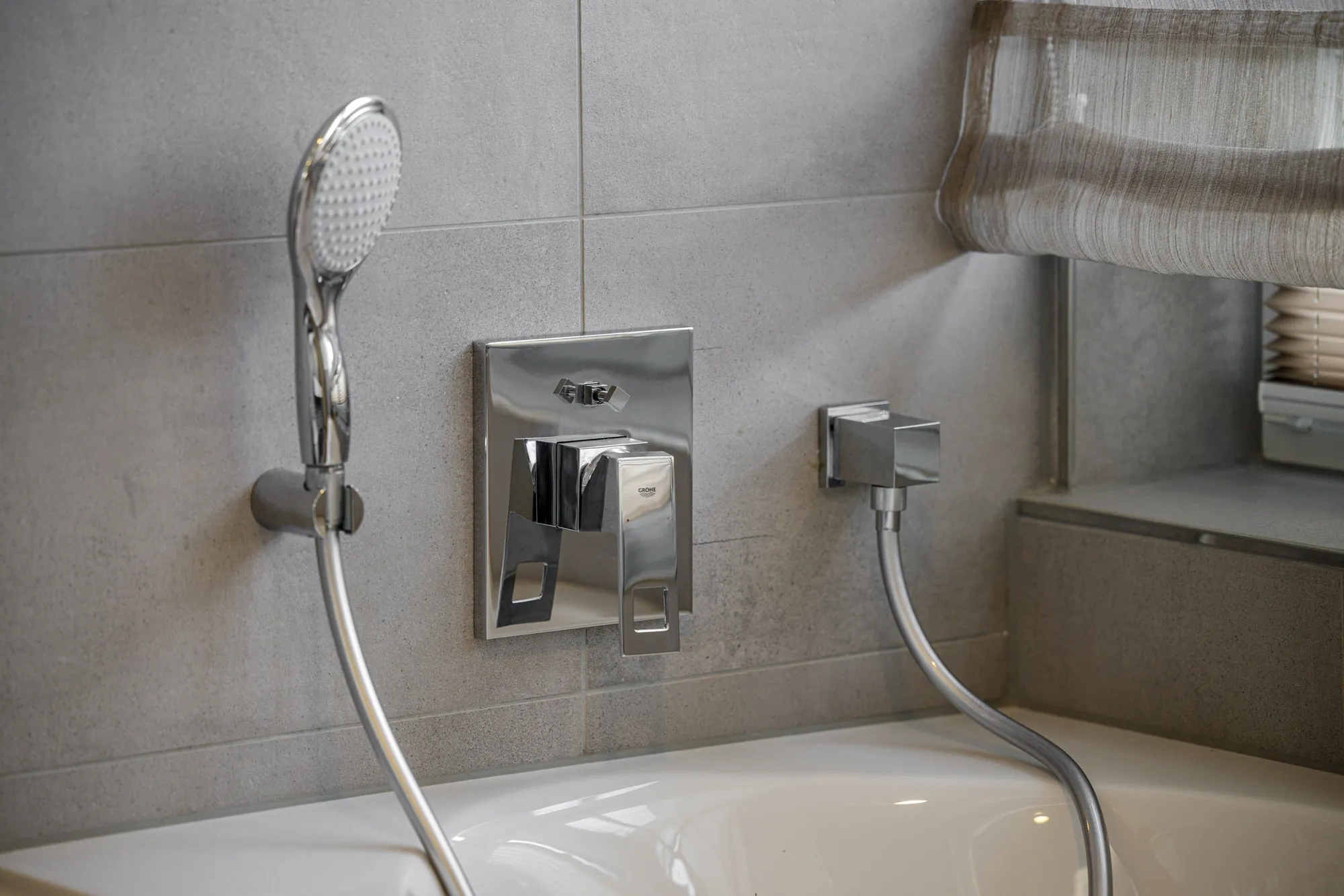 Armatur und Handbrause über der Badewanne im Detail