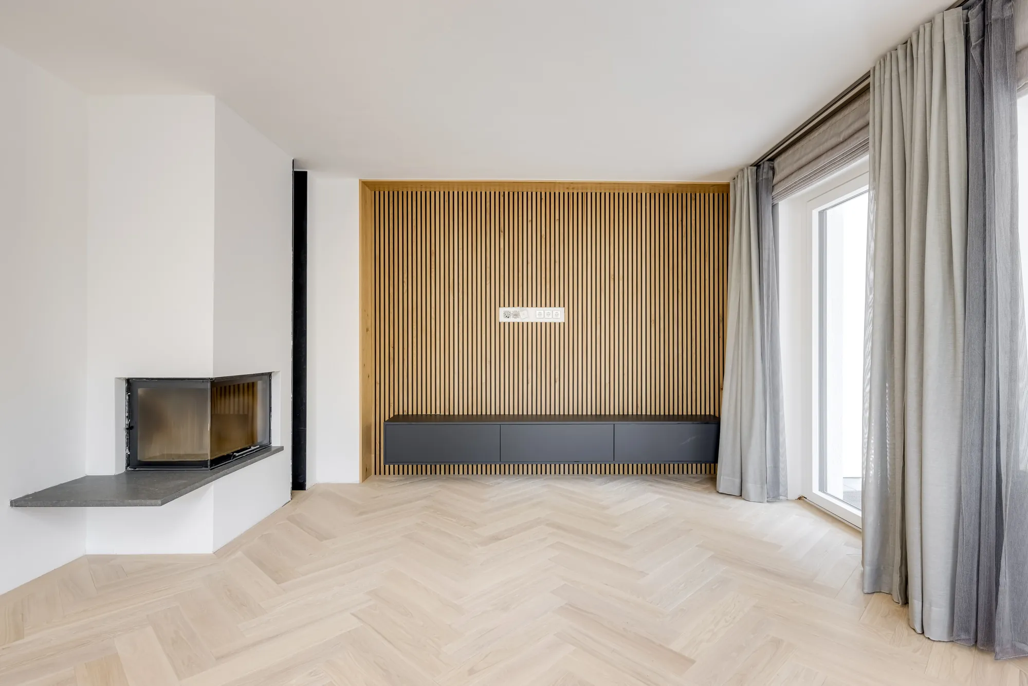 Wohnraum mit Eckkamin und Holzlamellenwand