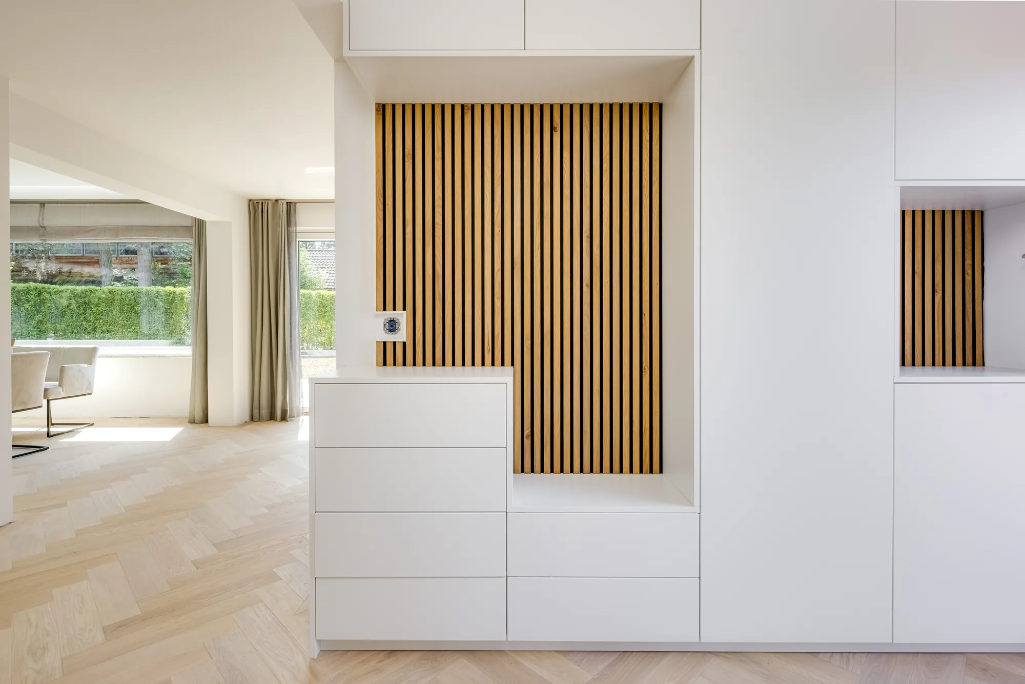 Einbauschrank mit Holzlamellen und Blick in den Garten