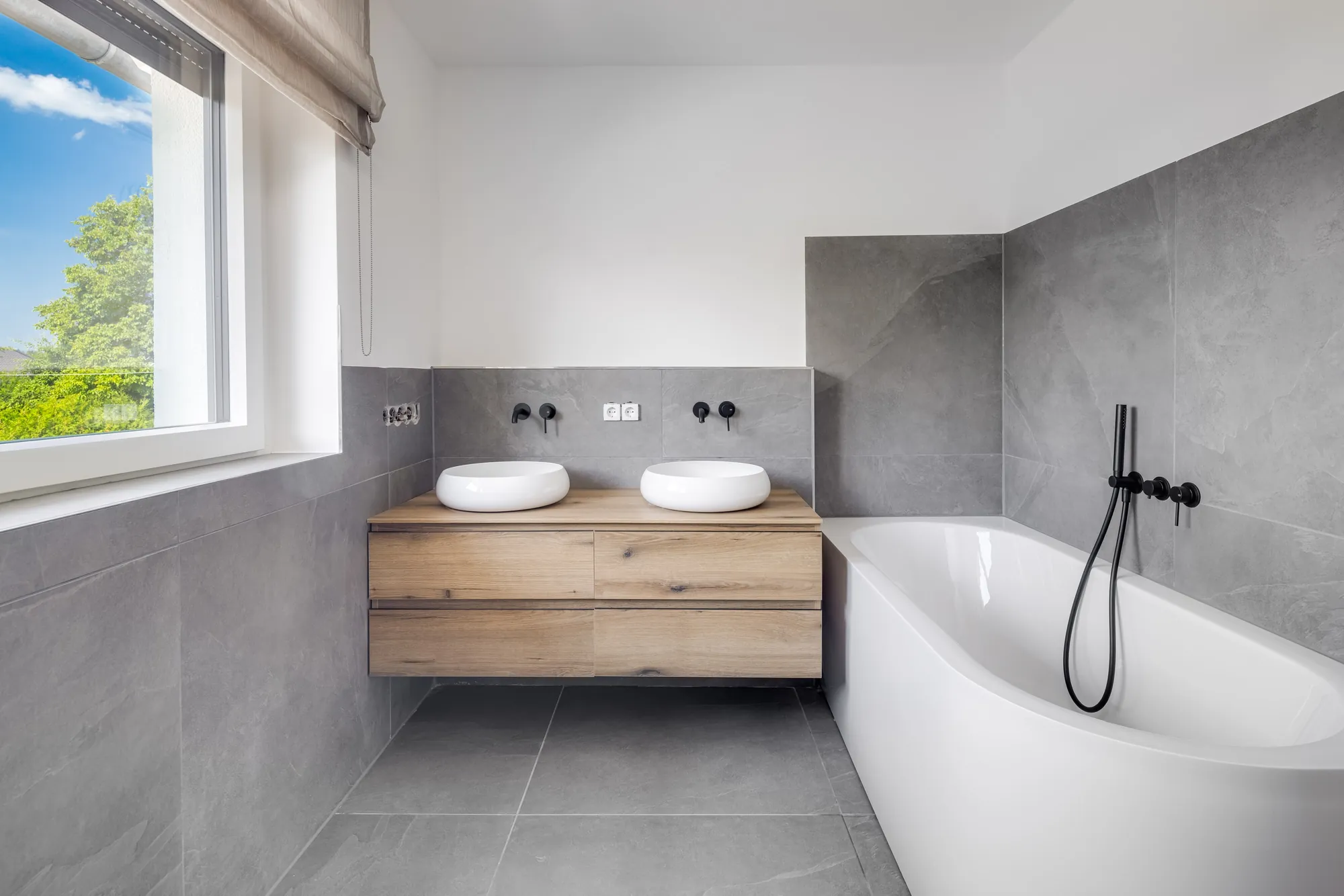 Bad mit freistehender Wanne, Doppelwaschtisch und schwarzen Armaturen