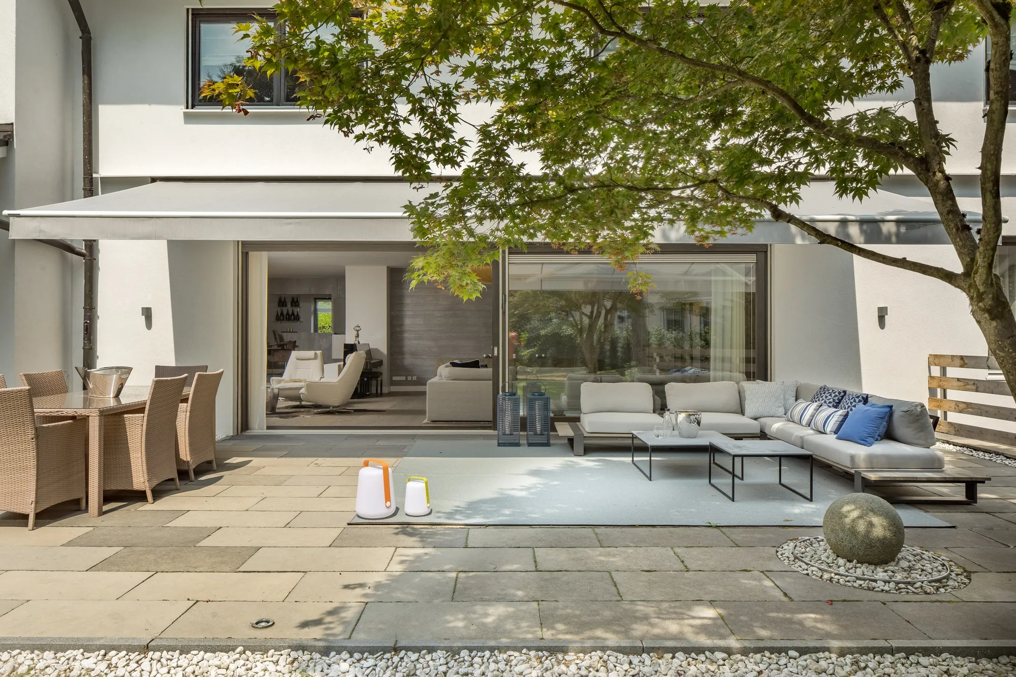 Terrasse mit Lounge und Essplatz vor großen Glastüren