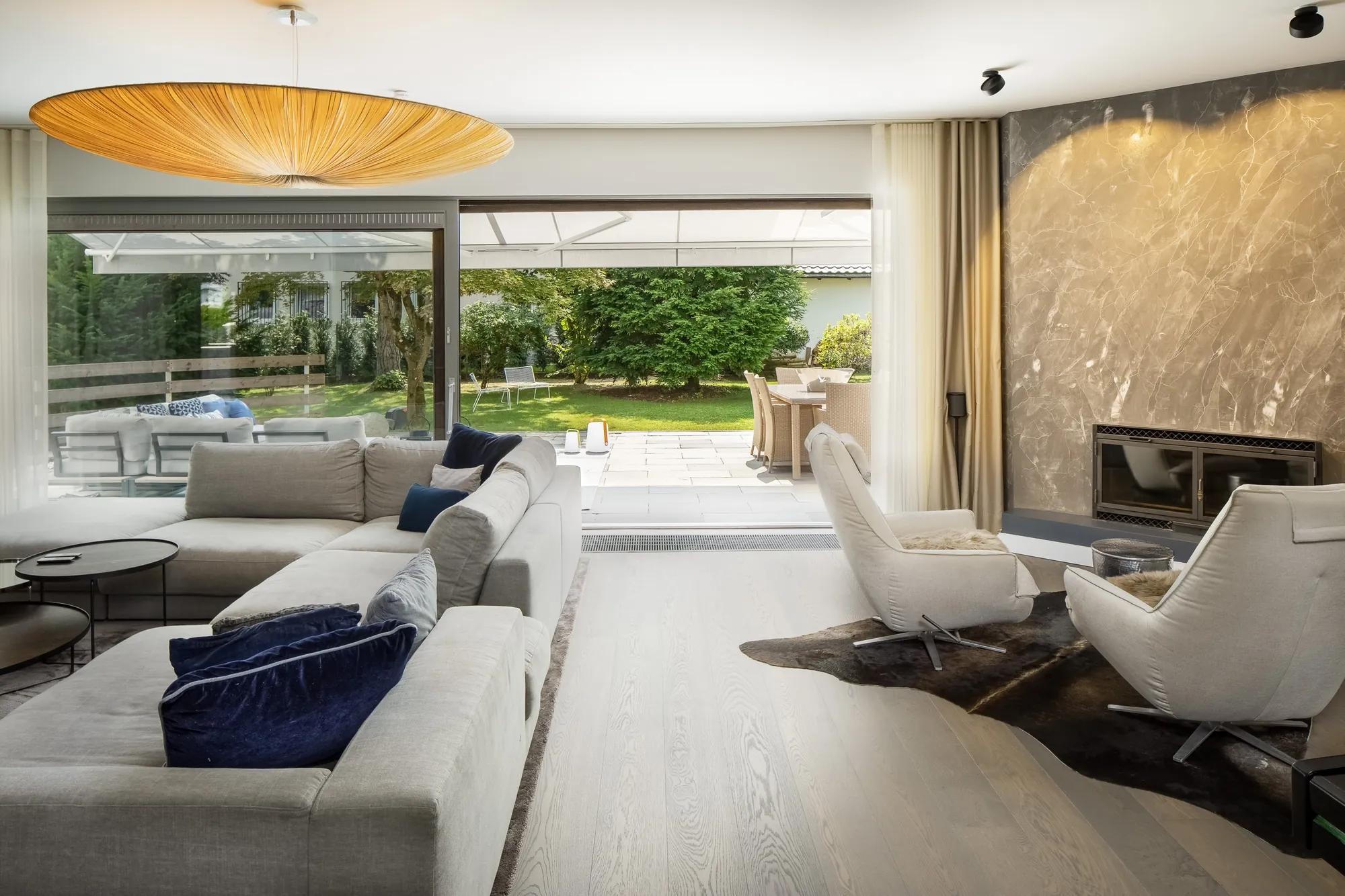 Wohnbereich mit Blick durch die Glasfront in den Garten