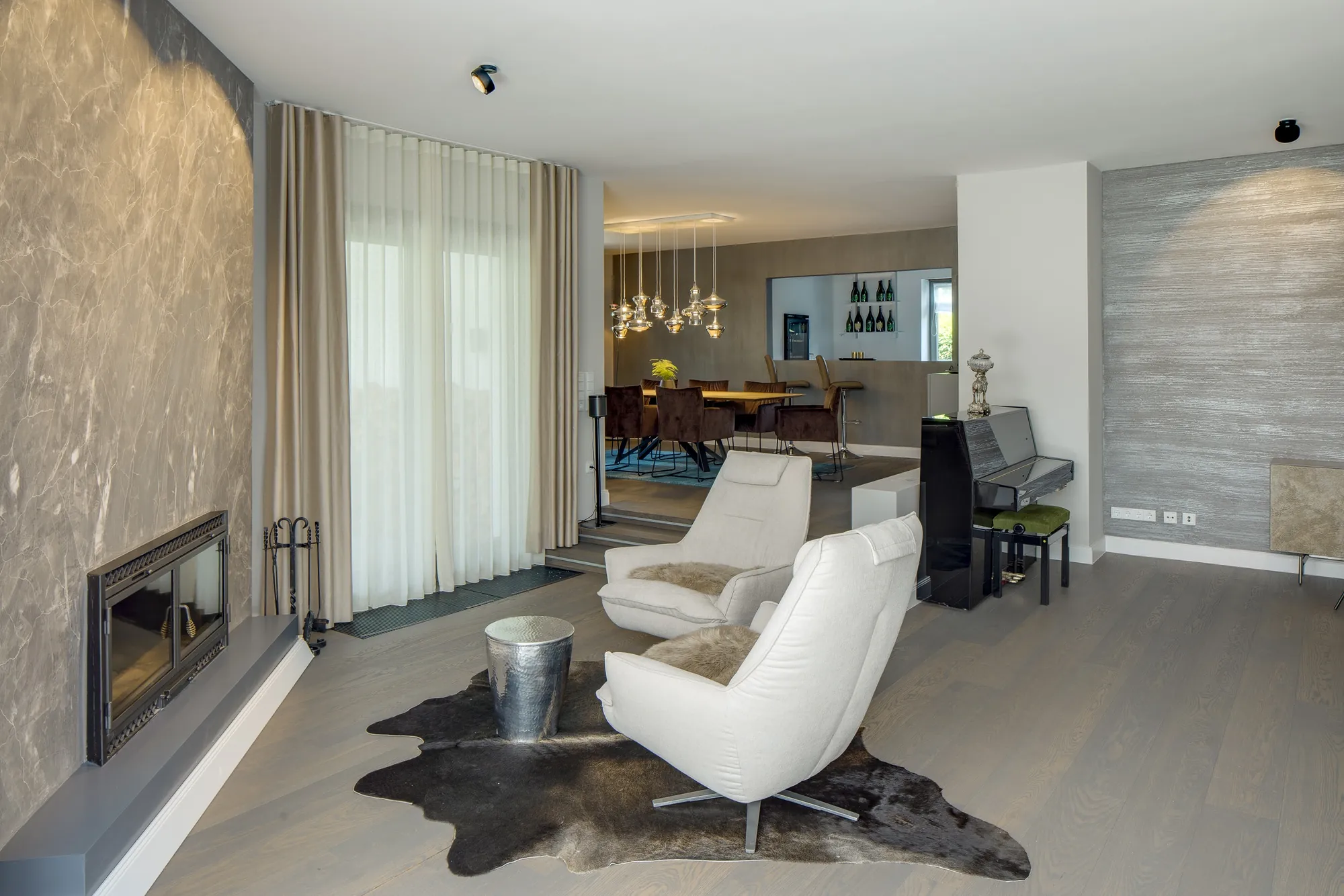 Kaminlounge mit zwei Sesseln und Natursteinwand