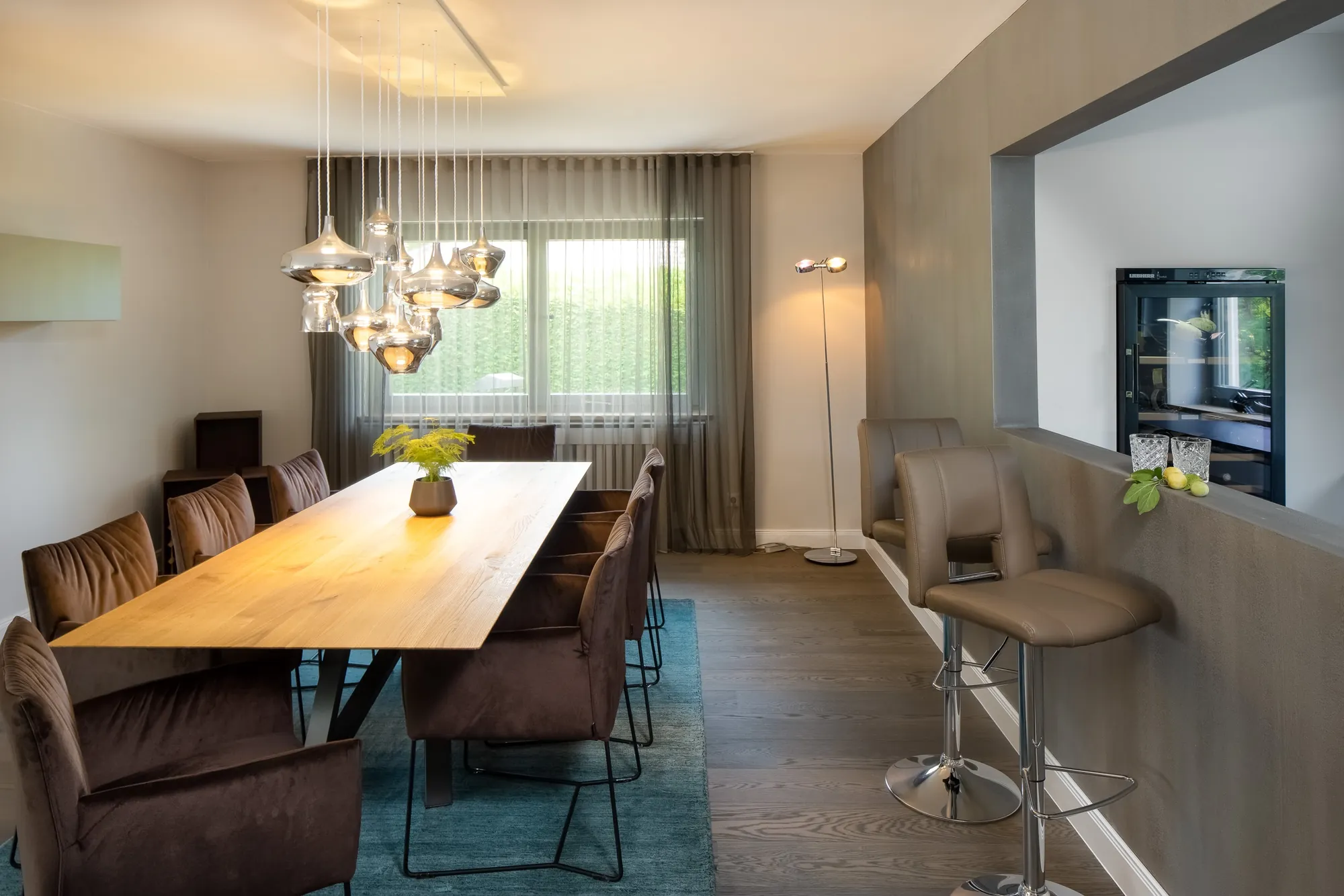 Essbereich mit langem Holztisch und Glasleuchten
