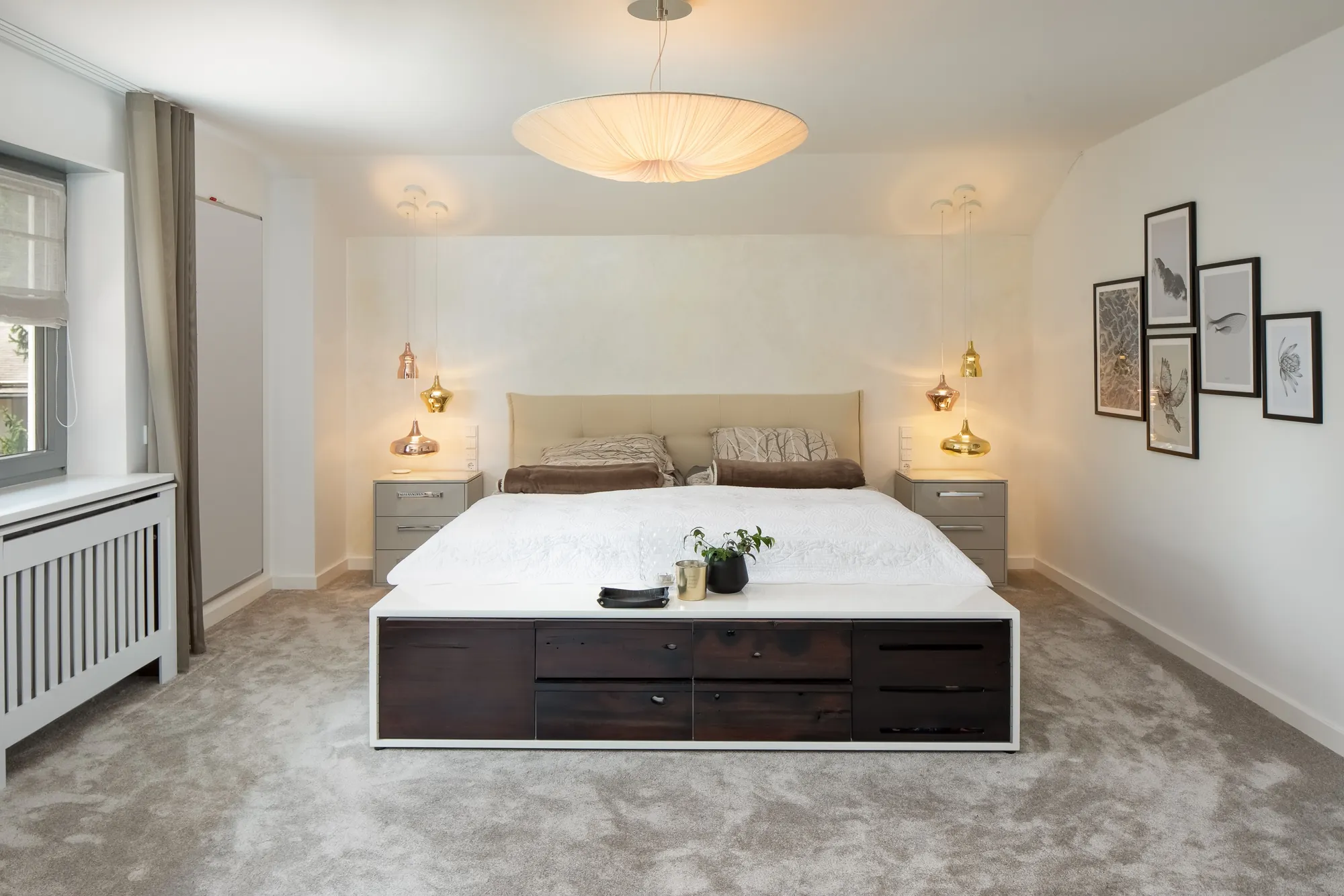 Schlafzimmer mit Leuchten und Bilderwand