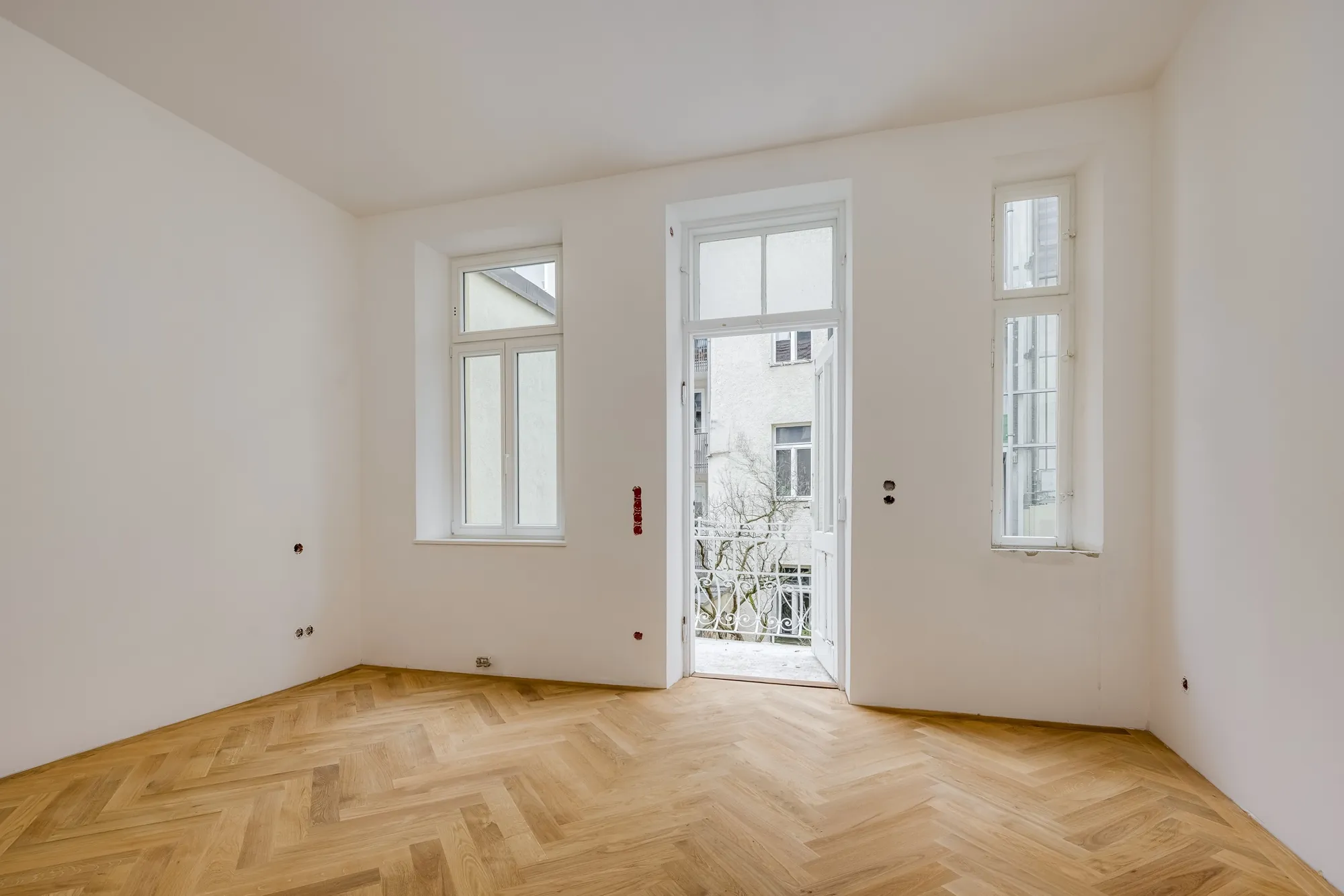 Altbauzimmer mit Balkontür und hohen Decken
