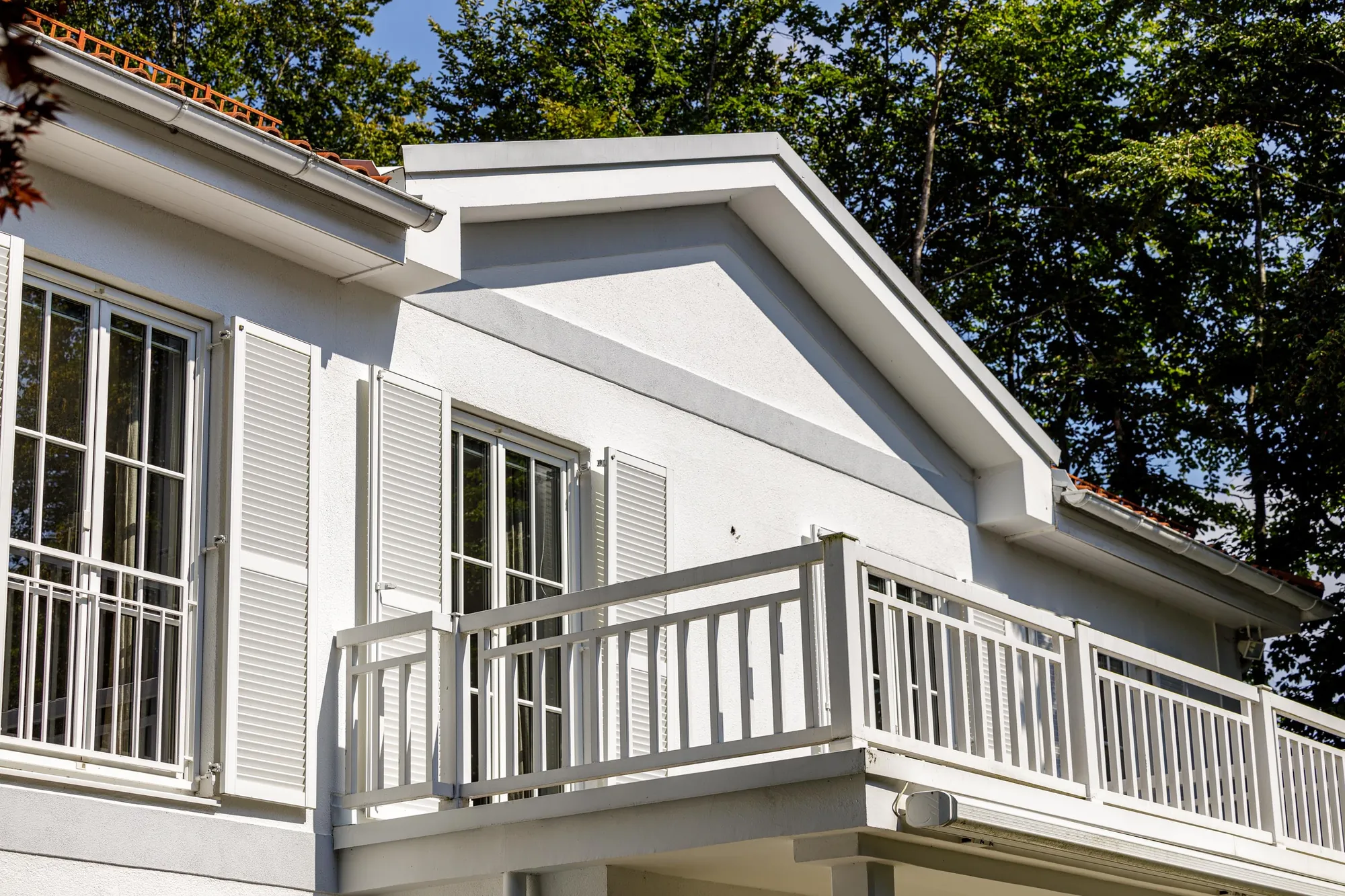 Balkon mit weißem Holzgeländer im Detail