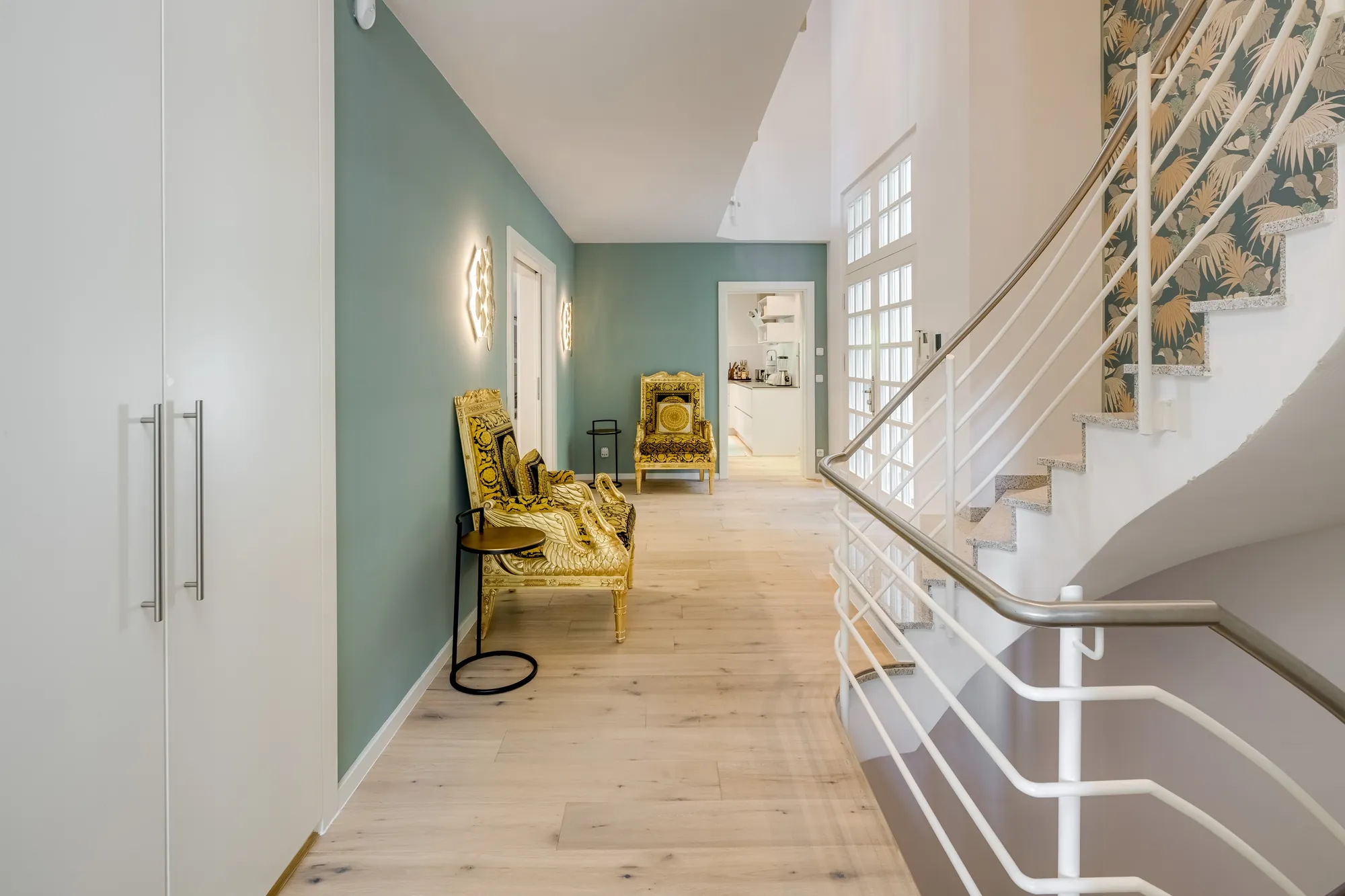 Diele mit geschwungener Treppe und mintgrüner Wand
