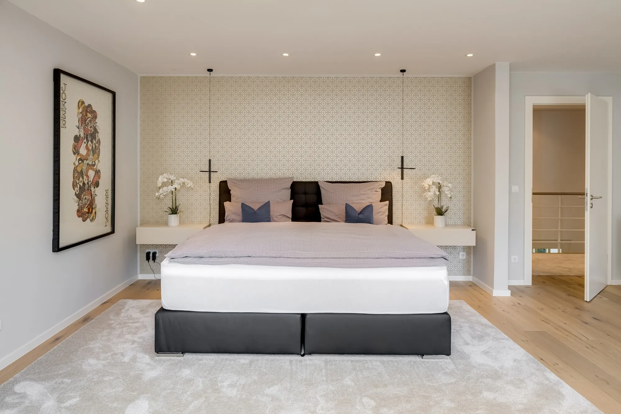 Schlafzimmer mit Designleuchten und Kunst