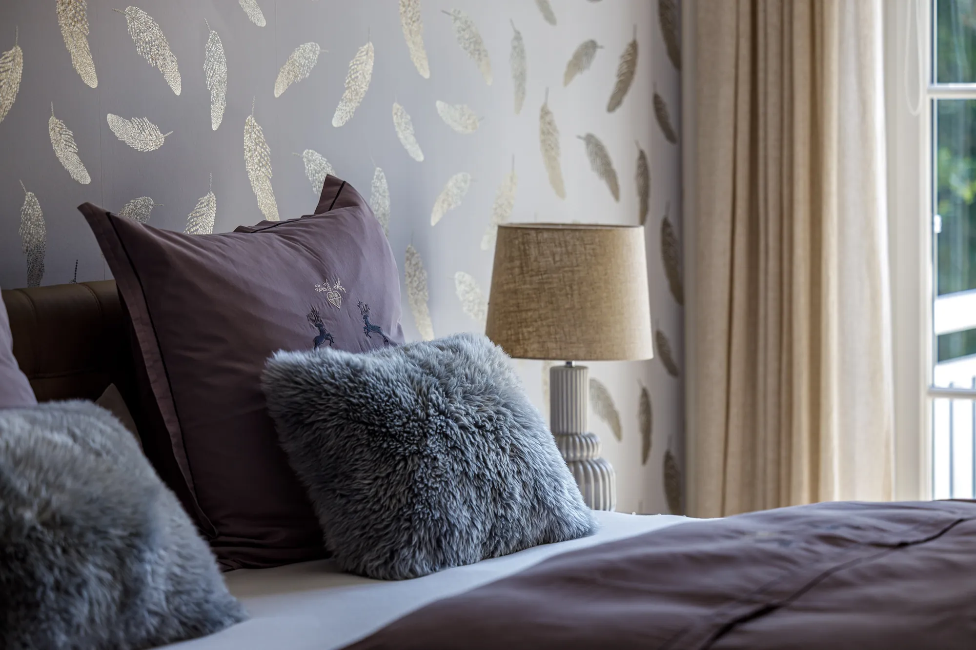 Kissen und Leuchte am Bett im Detail